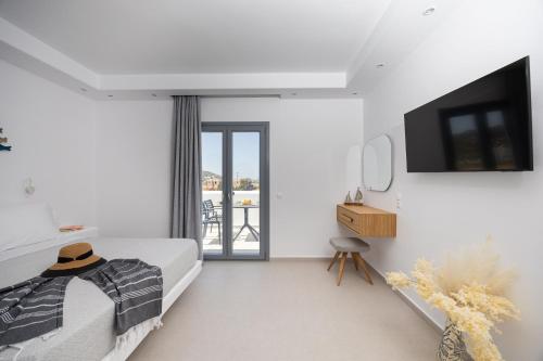 a bedroom with a bed and a tv on a wall at calmare collection hotel in Plaka