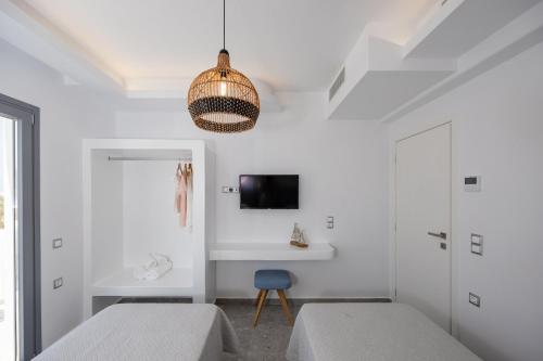 a bedroom with two beds and a tv on the wall at calmare collection hotel in Plaka