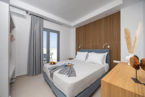 a bedroom with a bed and a large window at calmare collection hotel in Plaka