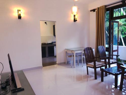 a living room with a table and chairs at Meritage Garden in Homagama
