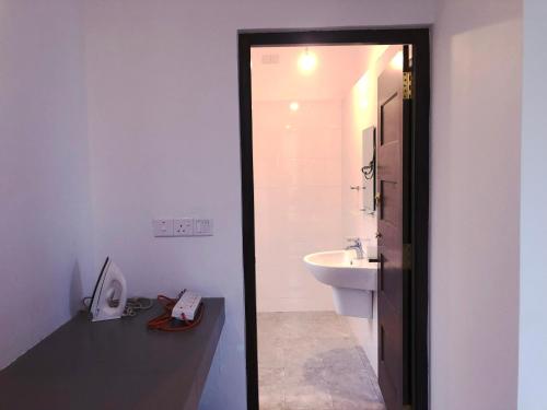 a bathroom with a sink and a white toilet at Meritage Garden in Homagama