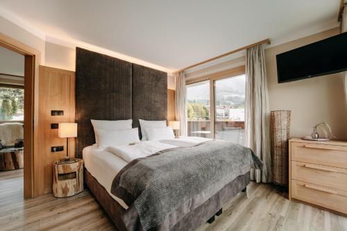 a bedroom with a large bed and a large window at Apartment Sella in Siusi
