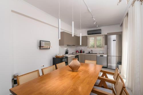 a dining room with a wooden table and a kitchen at Villa Eva By Milos Concierge in Adamas