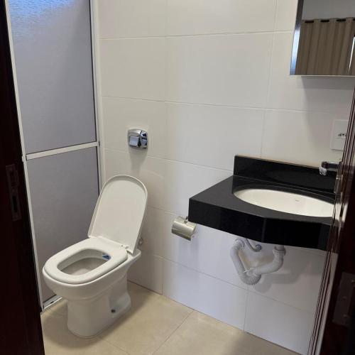 a bathroom with a toilet and a sink at Hotel Jatobás Sinop in Sinop