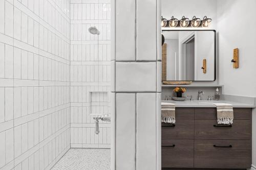 een witte badkamer met een wastafel en een spiegel bij Calivence Haus - Estate Home in Fredericksburg