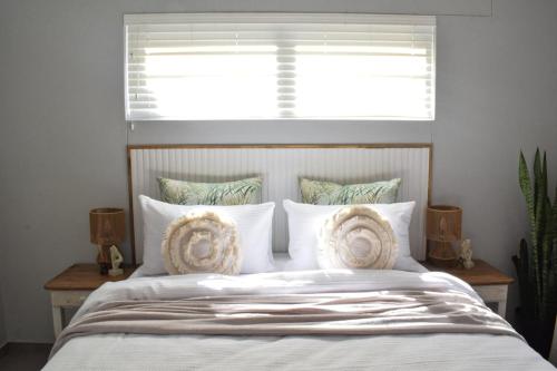 a bedroom with a bed with pillows and a window at Desert Nest II in Swakopmund
