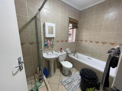 a bathroom with a sink and a toilet and a shower at Midrand Apartment near Mall of Africa in Midrand