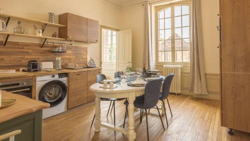 une cuisine avec une table et des chaises dans une pièce dans l'établissement La Suite du Manoir - Champagne et Sérénité, à Chappes