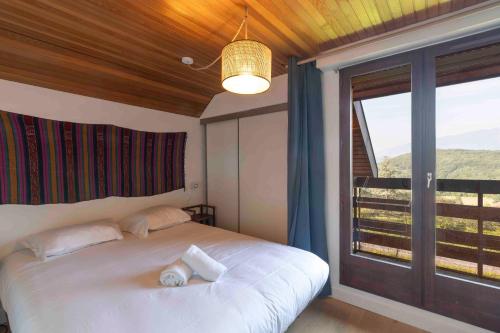 une chambre avec un lit et une grande fenêtre dans l'établissement Cabana & Triplex Bleu d'Annecy - Lake View, Terrace, à Talloires