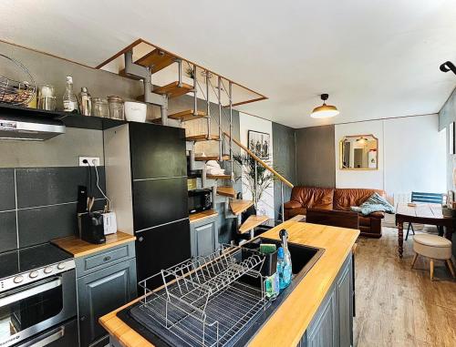 une cuisine avec un égouttoir à vaisselle sur la cuisinière dans l'établissement Le charmant Caponière, à Caen