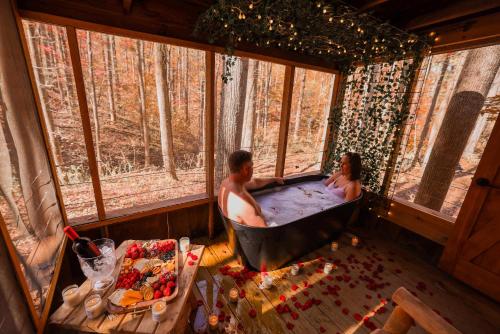 a man and woman in a bath tub in a room with windows at Ma & Pa's cabin at Cabin Fever in NC in Saluda