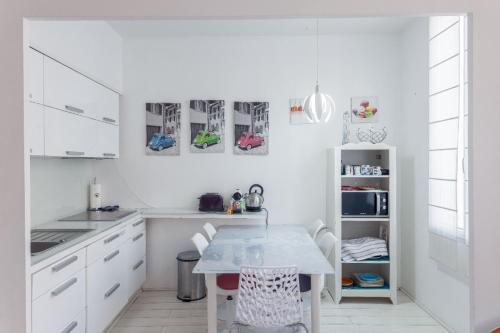 une cuisine blanche avec une table et des chaises dans l'établissement Duplex Jaurès - city center, AC, 10mn from Palais, à Cannes