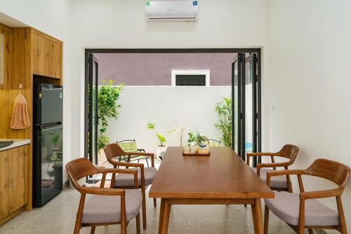a dining room with a wooden table and chairs at Hayden Home Ocean Park 3 in Ðình Loan