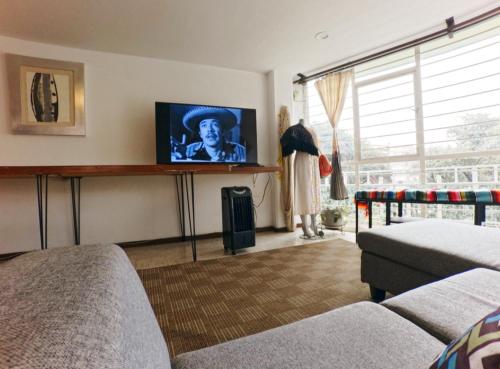 a living room with a tv and a couch at Mexicaníssima 4BR, 4 to 11 guests in Coyoacán in Mexico City
