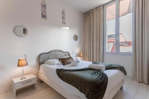 une chambre avec un lit et une grande fenêtre dans l'établissement Duplex Jaurès - city center, AC, 10mn from Palais, à Cannes