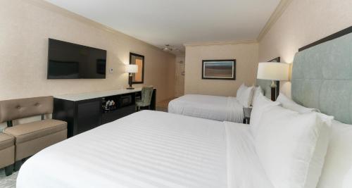 a hotel room with two beds and a flat screen tv at Prestige Lakeside Resort, WorldHotels Elite in Nelson