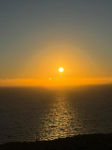 a sunset over the ocean with the sun in the sky at Thea Dysis A in Areopolis