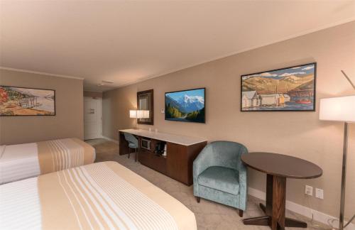 a hotel room with a bed and a desk and a table at Prestige Lakeside Resort, WorldHotels Elite in Nelson