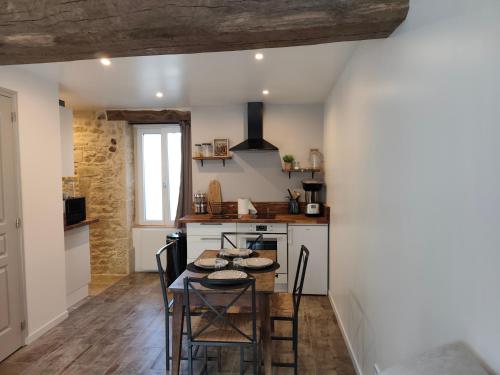 une cuisine avec une table et des chaises dans une pièce dans l'établissement Les bulles de Lys, 