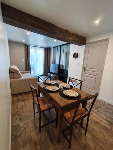 un salon avec une table et des chaises en bois dans l'établissement Les bulles de Lys, 