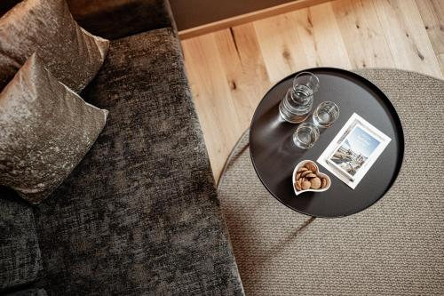 a table with two glasses and cookies on a couch at Panoramahotel Huberhof in Maranza