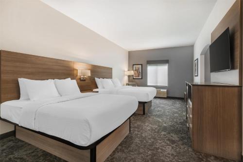 a hotel room with two beds and a flat screen tv at Best Western Manchester in Manchester