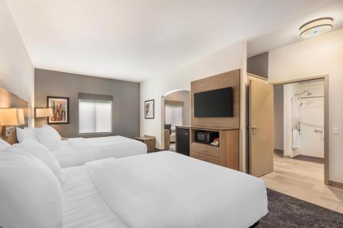 a hotel room with two beds and a flat screen tv at Best Western Manchester in Manchester