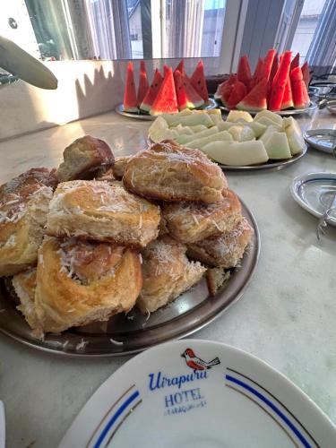 a plate of pastries and fruit on a table at Novo Hotel Uirapuru in Araraquara