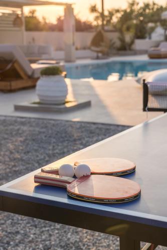 two bowls on a table next to a swimming pool at Villa Eva By Milos Concierge in Adamas