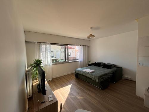 une chambre avec un lit et une grande fenêtre dans l'établissement Studio - bord de mer, à Les Sables-dʼOlonne