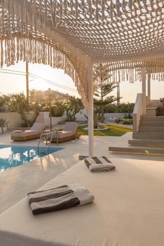 a white table with two napkins on it next to a pool at Villa Eva By Milos Concierge in Adamas