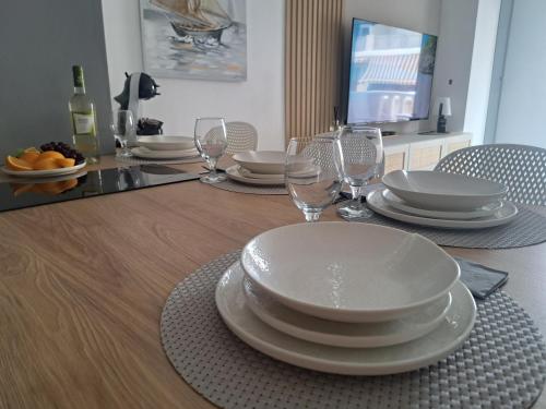 a dining room table with plates and wine glasses at Paradiso de Playa LaMata in La Mata