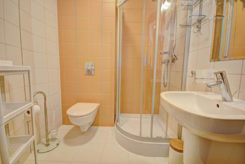 a bathroom with a shower and a toilet and a sink at HelApart - Foka in Hel