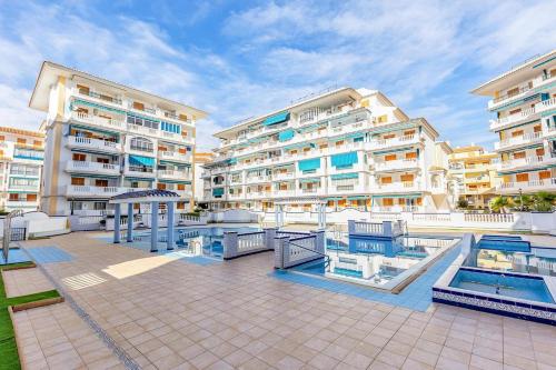 a large apartment complex with a swimming pool and buildings at Paradiso de Playa LaMata in La Mata
