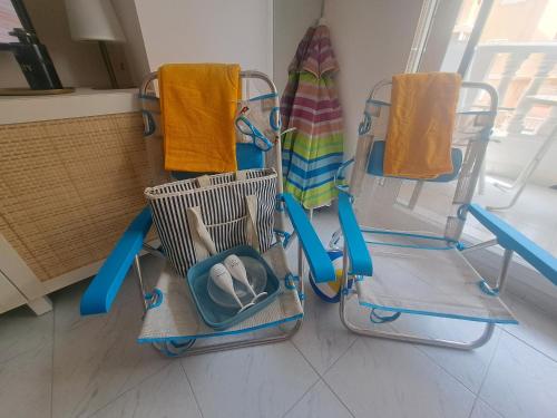 three chairs with towels and a surfboard on them at Paradiso de Playa LaMata in La Mata