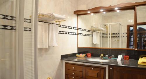 a bathroom with a sink and a shower with a mirror at Seehotel Porcia in Pörtschach am Wörthersee