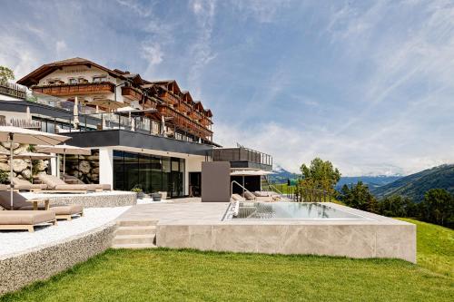 a house on a hill with a swimming pool at Panoramahotel Huberhof in Maranza
