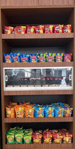 a shelf filled with lots of bags of chips at Novo Hotel Uirapuru in Araraquara