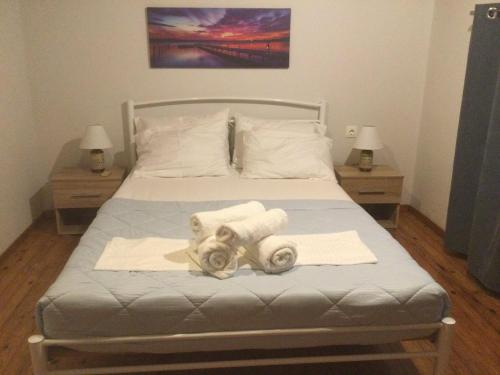 a bedroom with a bed with towels on it at Harmony House Corfu in Kynopiástai