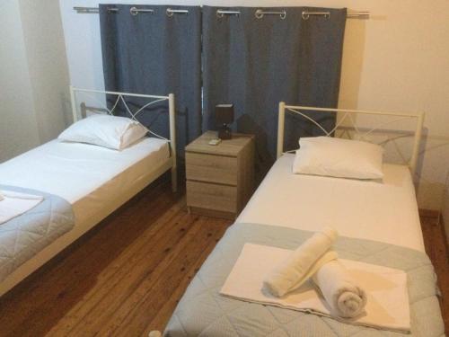 two twin beds in a room with blue curtains at Harmony House Corfu in Kynopiástai