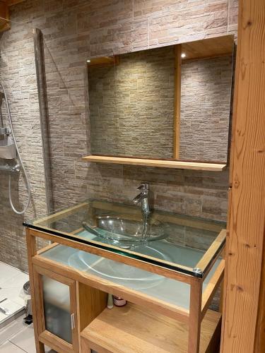 La salle de bains est pourvue d'un lavabo et d'un comptoir en verre. dans l'établissement Cozy apartment with a view, à Samoëns