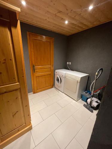 - une buanderie avec un lave-linge et une porte dans l'établissement Cozy apartment with a view, à Samoëns