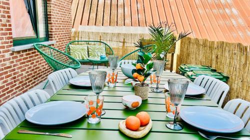 a green table with plates and oranges on it at Apartment for 6 people - near Brussels & Airport in Wezembeek-Oppem