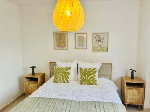 a bedroom with a bed with pillows and a yellow light at Apartment for 6 people - near Brussels & Airport in Wezembeek-Oppem