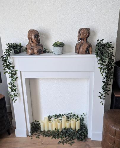 une cheminée avec des bougies et des statues dessus dans l'établissement Appartement cosy au coeur du centre historique de Bordeaux, à Bordeaux