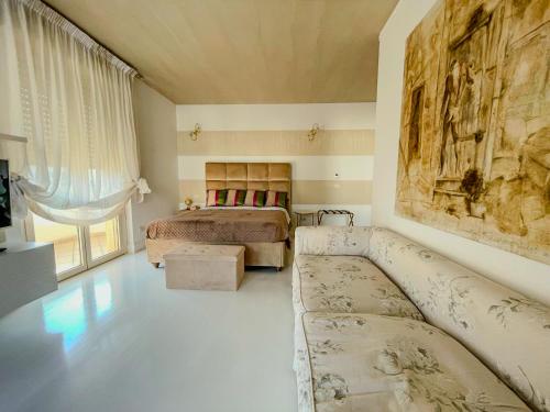 una camera da letto con due letti e un divano in una stanza di Mora Suite a Bari