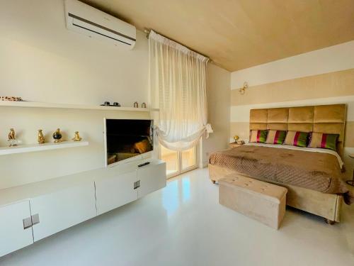 una camera da letto con un letto e una TV di Mora Suite a Bari