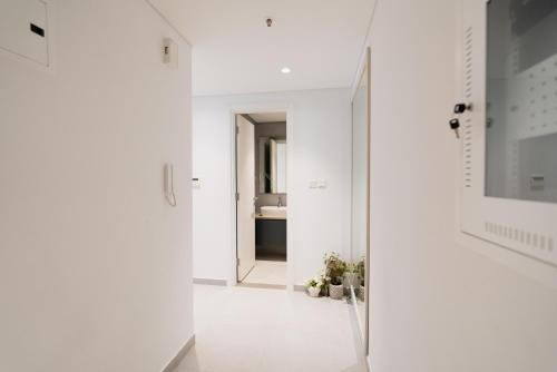 a hallway with white walls and a mirror at Sharjah apartment by Stay Bnb in Sharjah