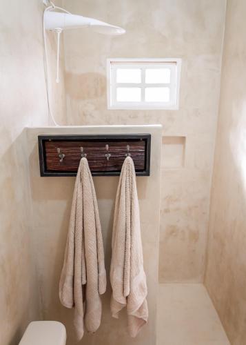 a bathroom with two towels hanging on a wall at Casa Azul in Trancoso