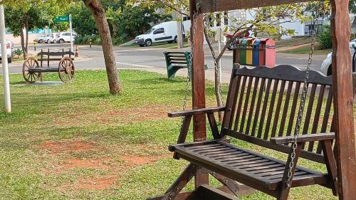 a wooden bench chained to a swing in a park at Diamante em Brasília in Brasilia
